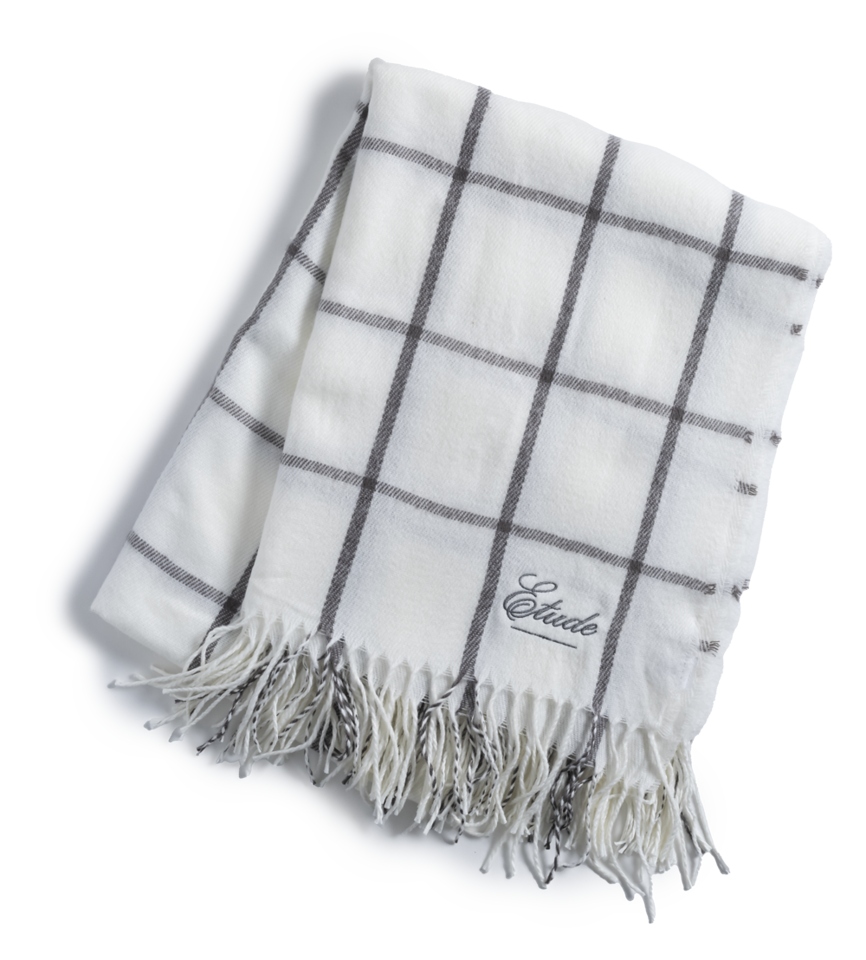 White plaid scarf with fringe and the word "Etude" embroidered on it.